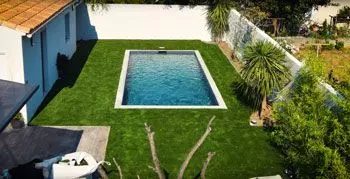 Jardin avec piscine et gazon synthétique posé sur sol meuble
